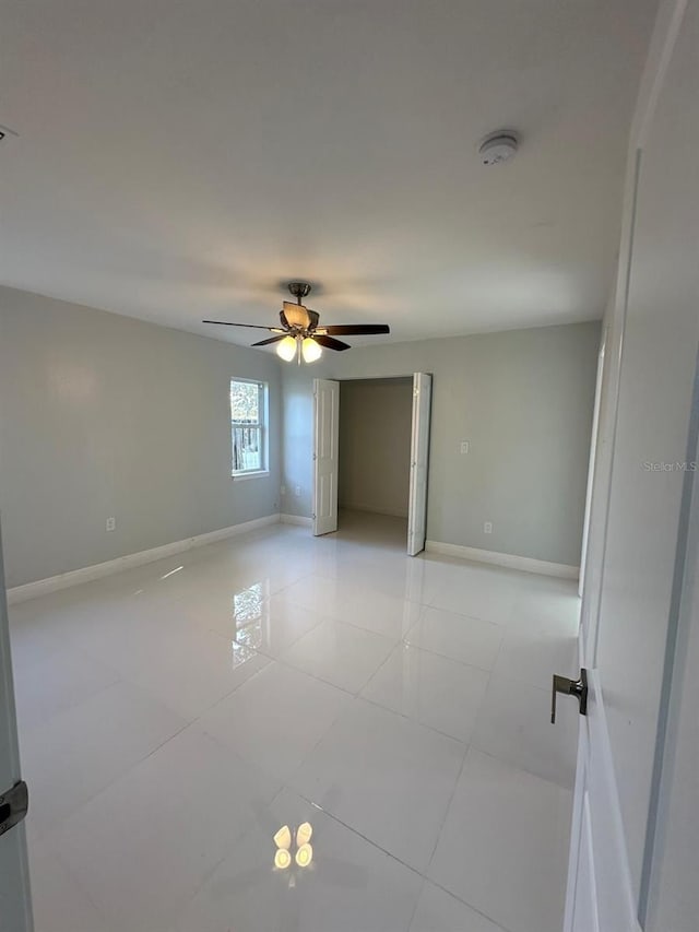 unfurnished room featuring ceiling fan and light tile patterned floors