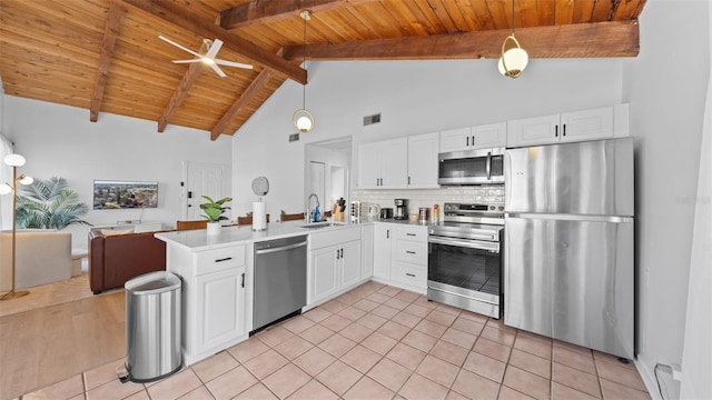 kitchen featuring white cabinets, decorative light fixtures, stainless steel appliances, and high vaulted ceiling