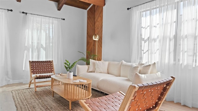 living area with hardwood / wood-style floors and vaulted ceiling with beams