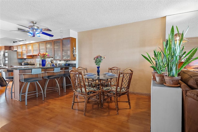 dining room with ceiling fan, dark hardwood / wood-style floors, and a textured ceiling