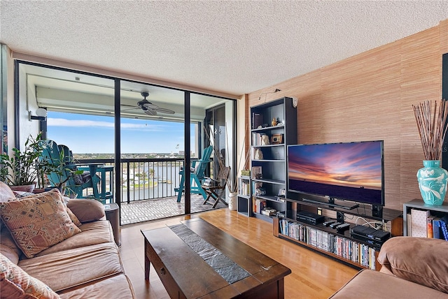 living room featuring hardwood / wood-style flooring, ceiling fan, floor to ceiling windows, and a textured ceiling