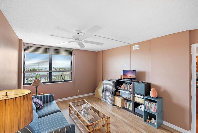 sitting room featuring hardwood / wood-style flooring, a textured ceiling, and ceiling fan