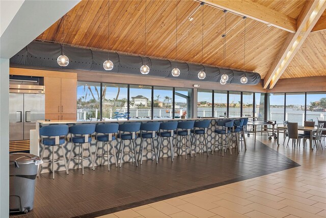 interior space featuring a healthy amount of sunlight, a water view, stainless steel built in fridge, and wood ceiling