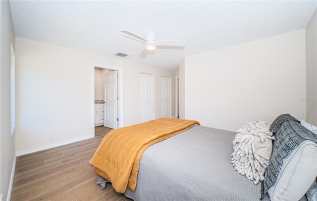 bedroom featuring connected bathroom, ceiling fan, and wood-type flooring