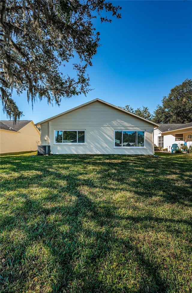 exterior space featuring cooling unit and a lawn