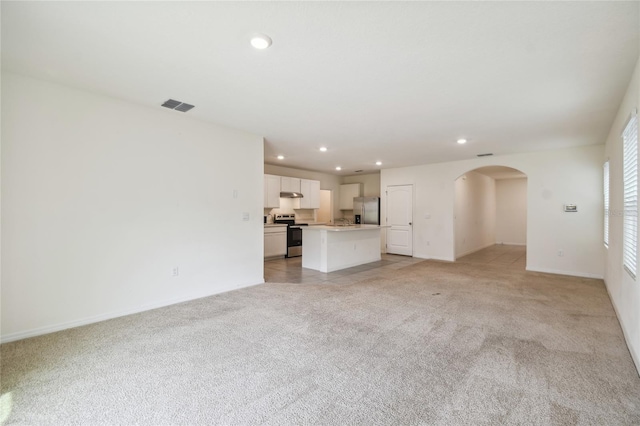 unfurnished living room featuring light colored carpet