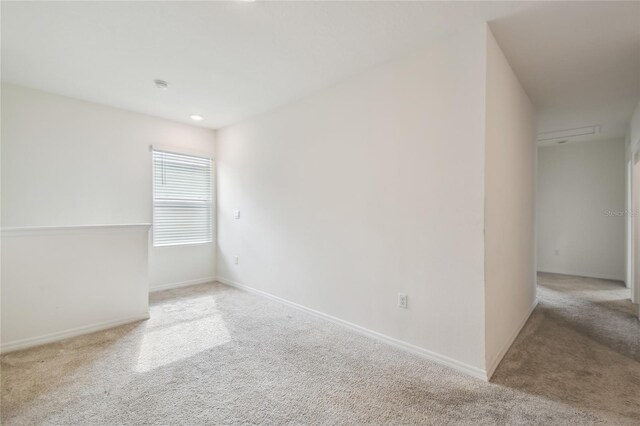 unfurnished room featuring light colored carpet