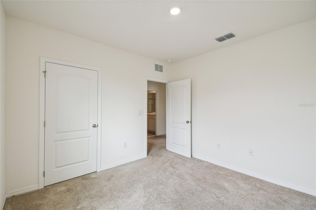 unfurnished bedroom featuring light carpet