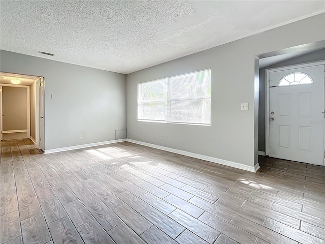 entryway with a textured ceiling and light hardwood / wood-style flooring