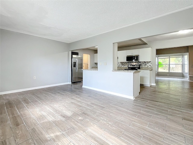 interior space with light stone countertops, tasteful backsplash, light hardwood / wood-style floors, white cabinetry, and stainless steel appliances