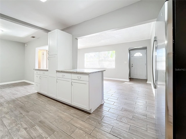 kitchen featuring white cabinets, light hardwood / wood-style floors, and stainless steel refrigerator