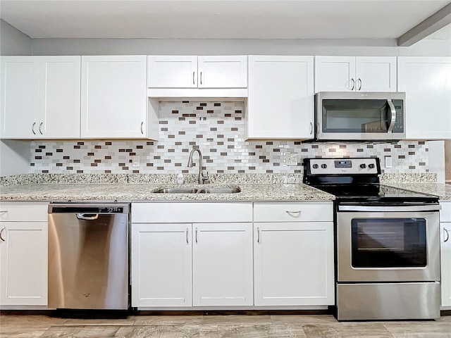 kitchen with backsplash, sink, white cabinets, and appliances with stainless steel finishes