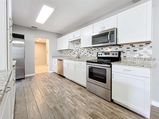 kitchen with white cabinets, stainless steel appliances, and sink