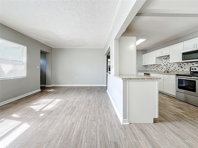 kitchen with white cabinetry, stainless steel appliances, and light hardwood / wood-style flooring