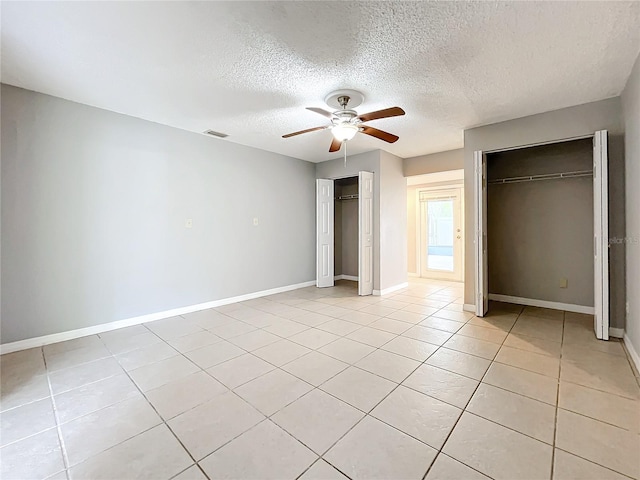 unfurnished bedroom featuring ceiling fan, light tile patterned flooring, and a textured ceiling