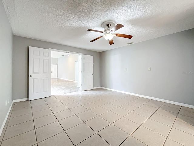 tiled spare room featuring ceiling fan and a textured ceiling