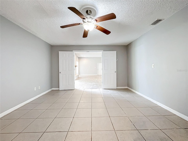 tiled spare room featuring ceiling fan and a textured ceiling