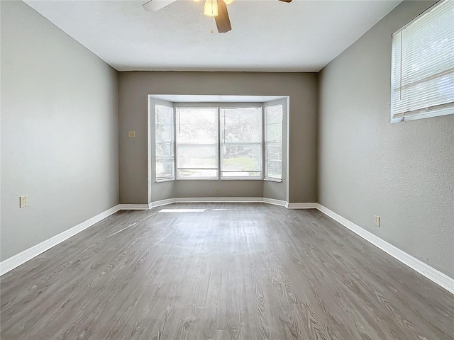 empty room with hardwood / wood-style floors and ceiling fan