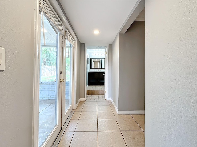 corridor featuring light tile patterned floors and french doors