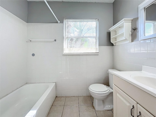 full bathroom with vanity, tile walls, tile patterned flooring, toilet, and tiled shower / bath