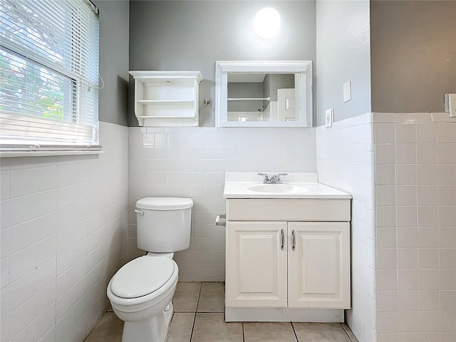 bathroom featuring tile patterned flooring, vanity, tile walls, and toilet