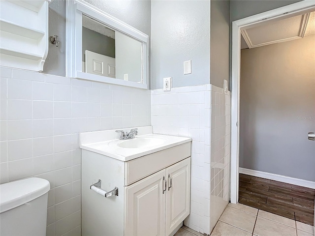 bathroom with hardwood / wood-style flooring, vanity, toilet, and tile walls