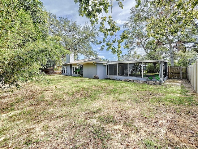 back of house with a sunroom and a yard