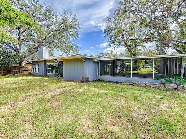 back of property featuring a sunroom and a yard