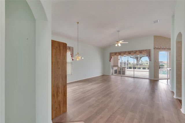 unfurnished living room with lofted ceiling, light hardwood / wood-style flooring, and ceiling fan with notable chandelier