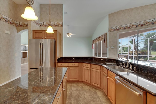 kitchen with pendant lighting, sink, vaulted ceiling, ceiling fan, and appliances with stainless steel finishes