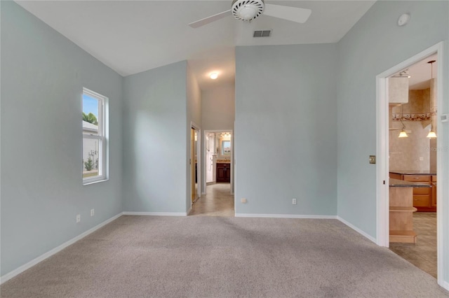 carpeted empty room with ceiling fan and vaulted ceiling