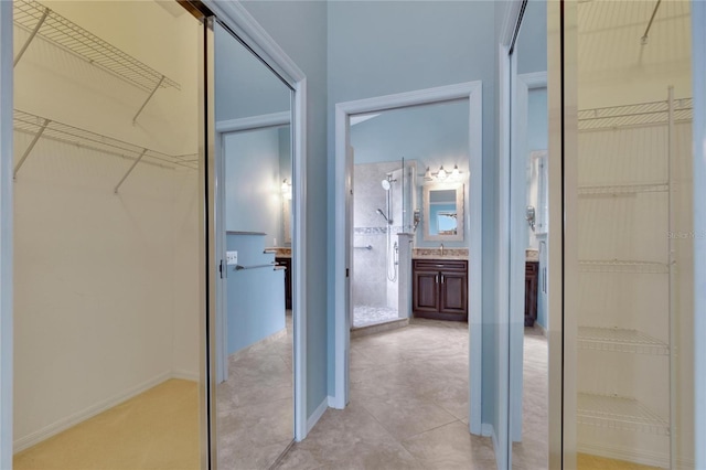 spacious closet featuring sink and light tile patterned flooring