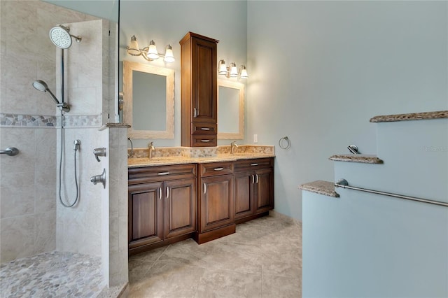 bathroom featuring tile patterned flooring, vanity, and tiled shower