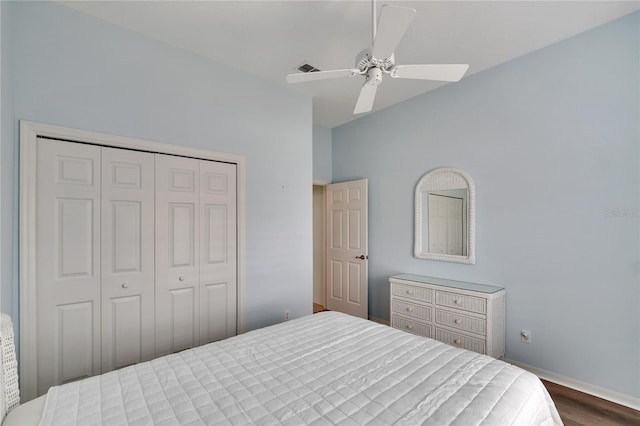 bedroom with ceiling fan, dark wood-type flooring, and a closet