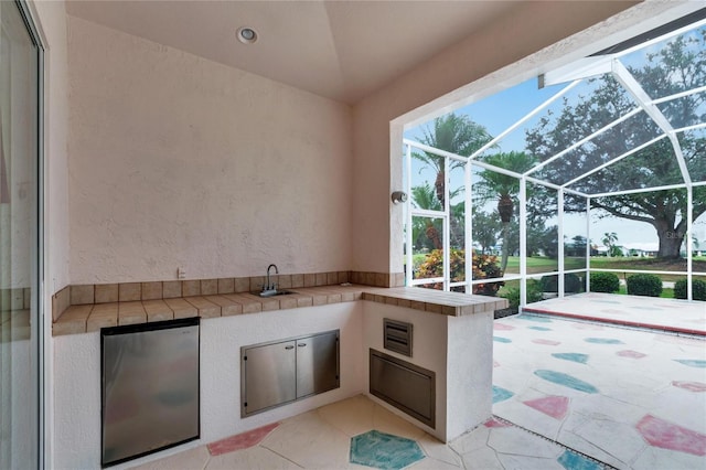 view of patio with glass enclosure and sink