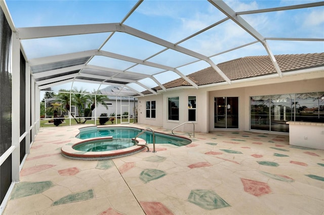 view of pool featuring an in ground hot tub, a patio, and glass enclosure