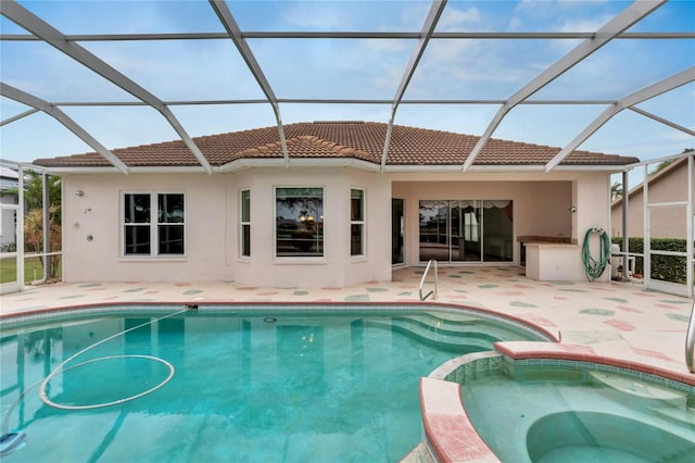 view of swimming pool featuring an in ground hot tub, glass enclosure, and a patio area