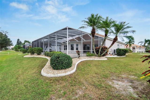 rear view of property with a lawn and glass enclosure