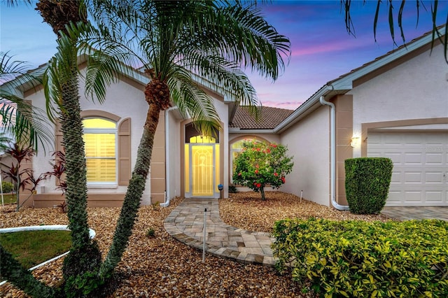 exterior entry at dusk with a garage