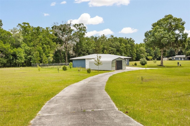 view of community featuring a lawn and an outbuilding