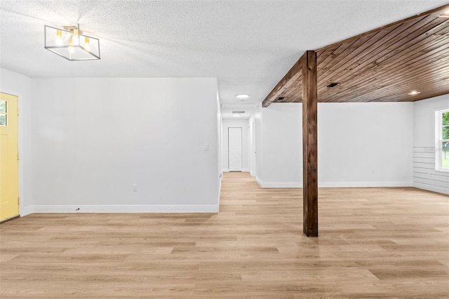 spare room with a textured ceiling and light wood-type flooring