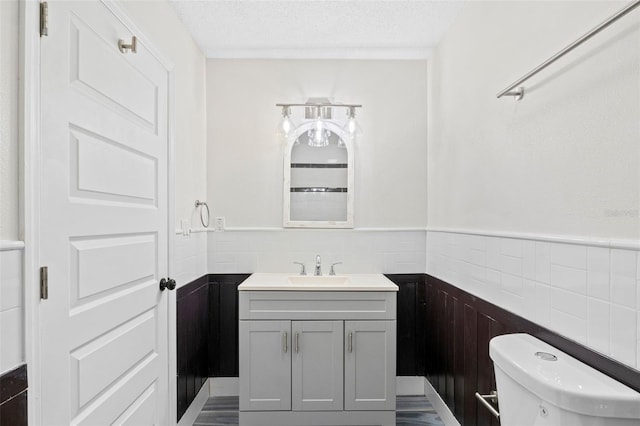 bathroom featuring vanity, a textured ceiling, and toilet