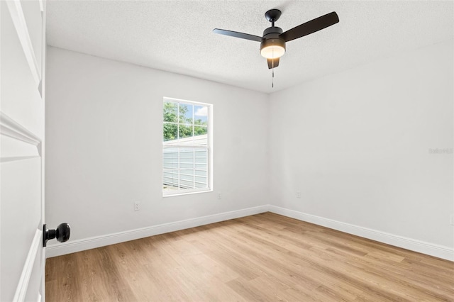 empty room featuring ceiling fan, light hardwood / wood-style floors, and a textured ceiling