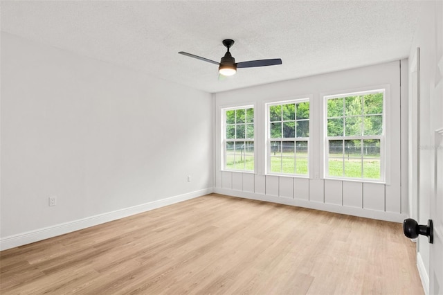 spare room with ceiling fan, light hardwood / wood-style flooring, a healthy amount of sunlight, and a textured ceiling