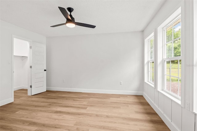 interior space with ceiling fan, a textured ceiling, and light hardwood / wood-style flooring