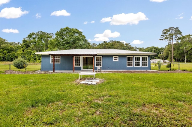 back of property with a yard and a patio