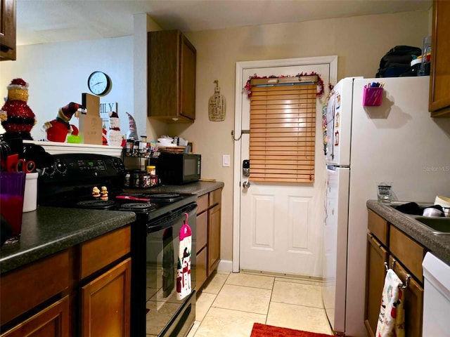 2302 Maki Rd Unit 5, Plant City, FL 33563 - kitchen featuring black appliances, light tile patterned floors, dark countertops, and brown cabinets