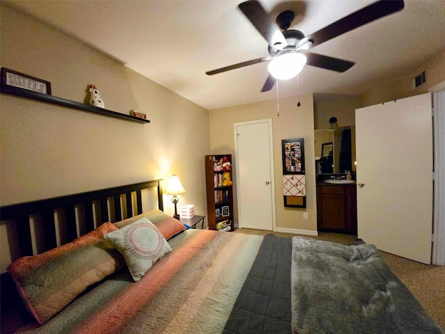 bedroom featuring ensuite bath, ceiling fan, and carpet