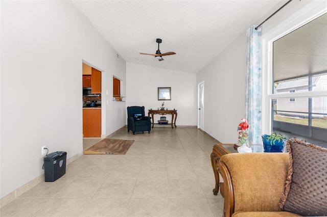 sitting room featuring ceiling fan, lofted ceiling, and light tile patterned flooring