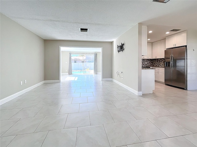 interior space featuring light tile patterned flooring and a textured ceiling